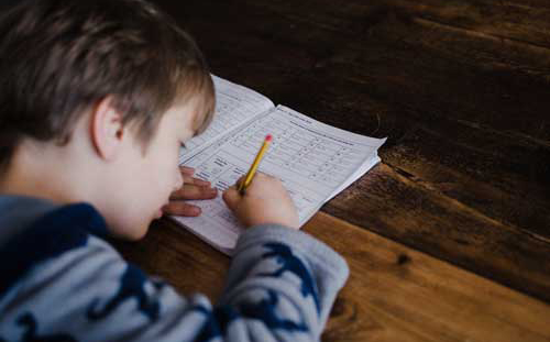 Kid solving a math problem on paper